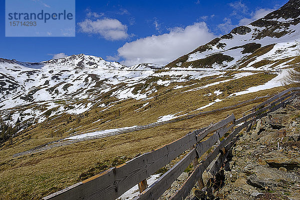 Italien  Südtirol  Einfacher Holzzaun am Penser Joch mit Schneeschmelze im Hintergrund