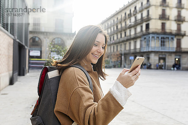 Glückliche junge Frau mit Mobiltelefon in der Stadt  Barcelona  Spanien