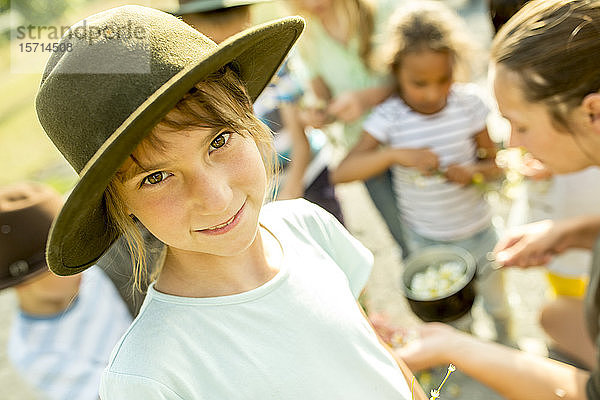 Schulkinder lernen  wie man einen Kamillenaufguss zubereitet  Mädchen lächelt in die Kamera