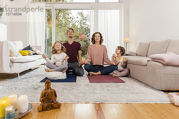 Gemeinsam meditierende Familie zu Hause