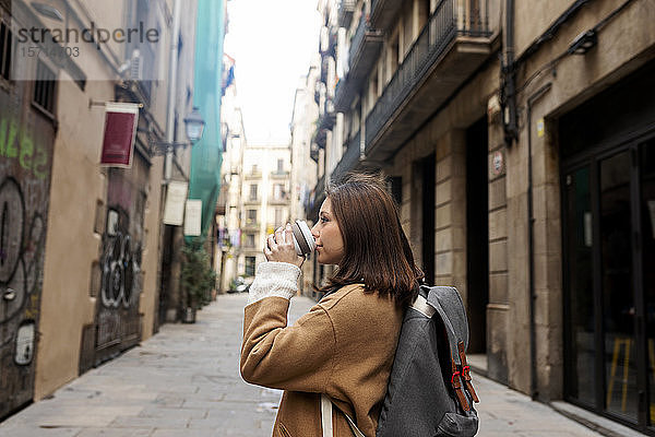Junge Frau mit Kaffee zum Mitnehmen in der Stadt  Barcelona  Spanien