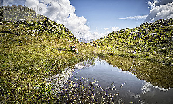 Junge  der am Bergsee sitzend eine Wanderpause einlegt  Passeiertal  Südtirol  Italien