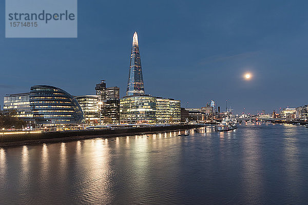 Großbritannien  England  London  die Themse und beleuchtete Wolkenkratzer am Wasser in der frühen Morgendämmerung
