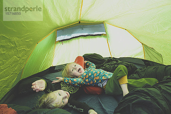 Geschwister spielen zusammen in einem Zelt