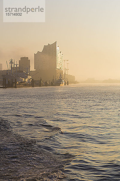 Deutschland  Hamburg  Silhouette der Elbphilharmonie bei Sonnenaufgang über den Fluss gesehen