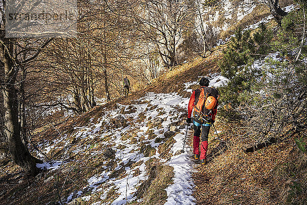 Zwei Wanderer wandern durch verschneiten Wald  Orobie-Alpen  Lecco  Italien