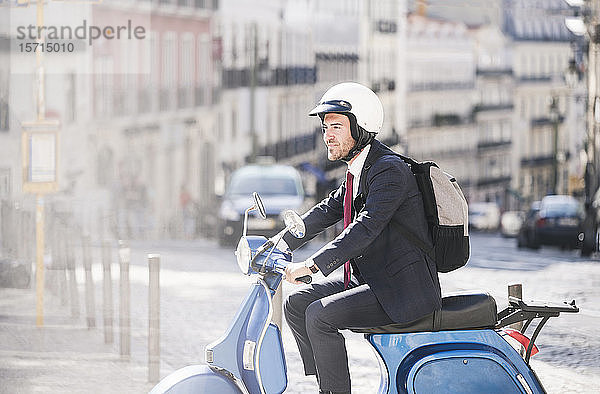 Junger Geschäftsmann fährt Motorroller in der Stadt  Lissabon  Portugal