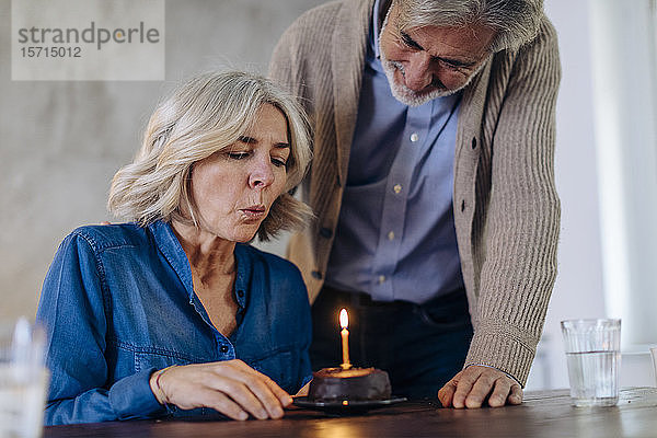 Älteres Paar feiert Geburtstag mit Kuchen in der heimischen Küche