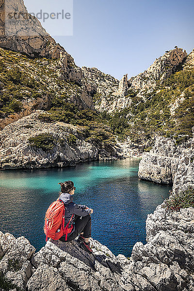 Frankreich  Côte d'Azur  Calanques-Nationalpark  Frau mit Rucksack  Blick auf Kreidefelsen und Buchten