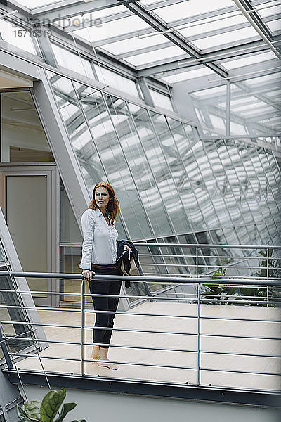 Porträt einer selbstbewussten Geschäftsfrau in einem modernen Bürogebäude