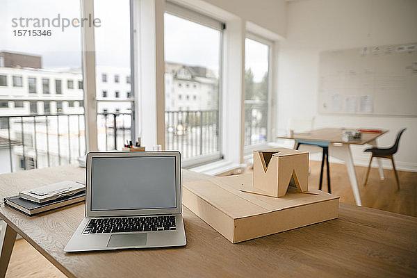 Architekturmodell und Laptop auf dem Schreibtisch im Büro