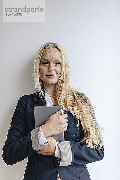 Porträt einer blonden jungen Geschäftsfrau mit Tablette in der Hand