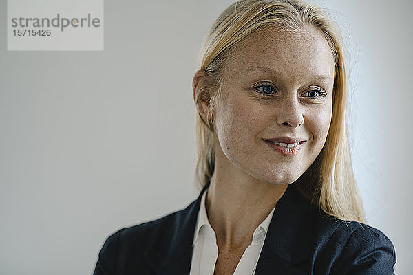 Porträt einer lächelnden blonden jungen Geschäftsfrau