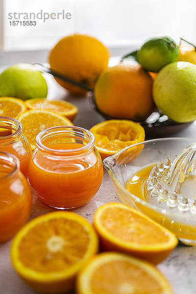 Frisch geschnittene Orangen und Gläser mit Orangensaft