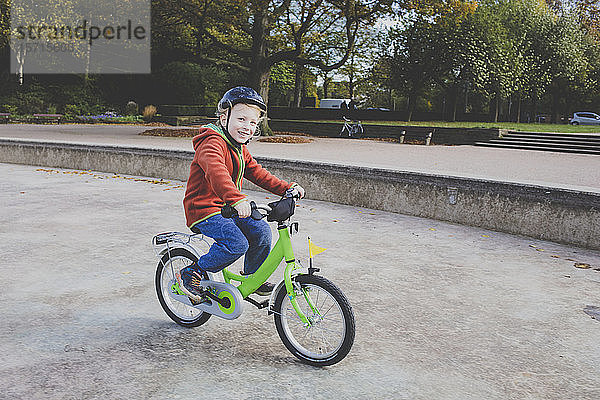 Porträt eines lächelnden kleinen Jungen beim Fahrradfahren