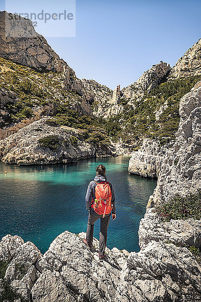 Frankreich  Côte d'Azur  Calanques-Nationalpark  Frau mit Rucksack  Blick auf Kreidefelsen und Buchten