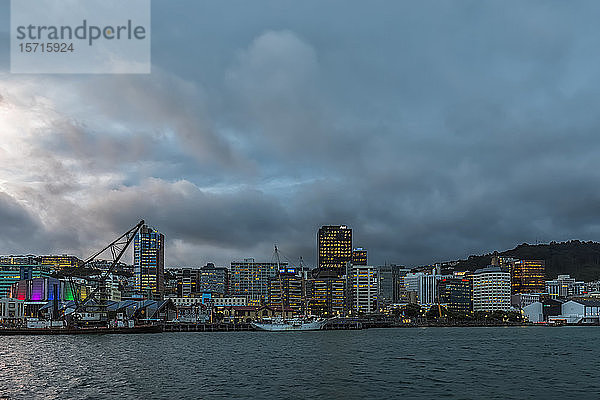 Neuseeland  Wellington  Wolken über der Skyline der Hafenstadt in der Abenddämmerung