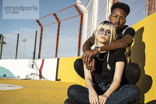 Porträt eines jungen Paares mit farbiger Sonnenbrille