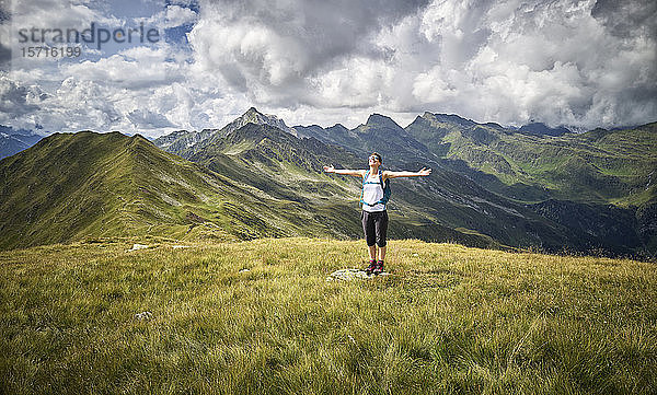 Fröhliche Frau  die eine Pause vom Wandern im Stehen auf der Alm macht  Passeiertal  Südtirol  Italien