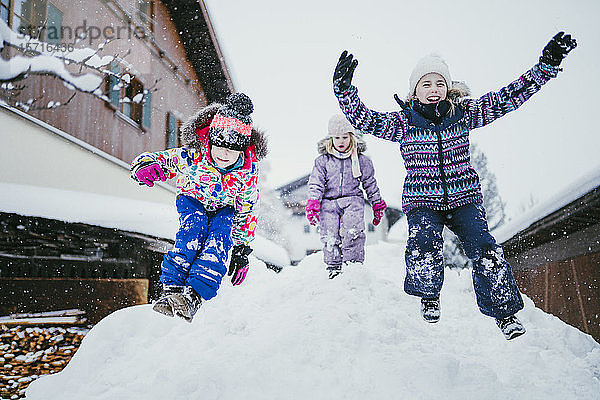 Drei Kinder spielen im Schnee  Jochberg  Österreich