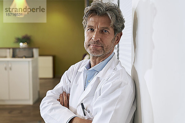 Porträt eines selbstbewussten Arztes in seiner medizinischen Praxis