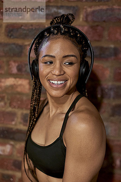 Porträt einer Sportlerin  die mit Kopfhörern Musik hört