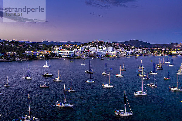 Spanien  Mallorca  Santa Ponsa  In der Abenddämmerung im Küstengewässer schwimmende Boote mit der Stadt im Hintergrund