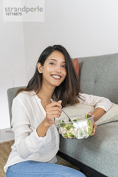 Porträt einer entspannten jungen Geschäftsfrau mit Schüssel mit gemischtem Salat
