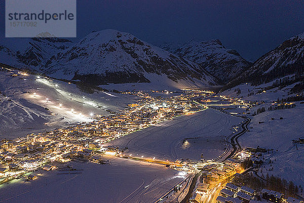 Italien  Provinz Sondrio  Livigno  Luftaufnahme einer beleuchteten Stadt in den italienischen Alpen in der Abenddämmerung