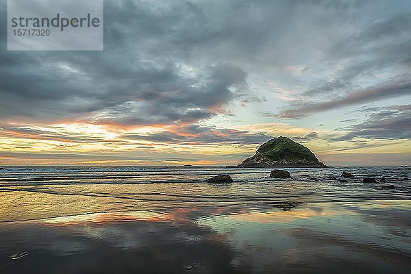 Neuseeland  Tongaporutu  Bewölkter Himmel über dem Sandstrand in der Abenddämmerung mit der Insel Motuotamatea im Hintergrund