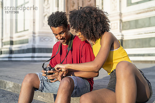Glückliches junges Touristenpaar macht eine Pause in der Stadt und schaut in die Kamera  Florenz  Italien