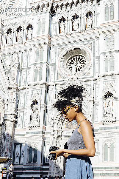 Junge Frau mit Kamera vor der Kathedrale stehend  Florenz  Italien