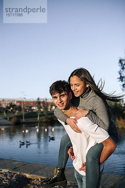 Porträt eines glücklichen Teenagers  der seine Freundin Huckepack nimmt