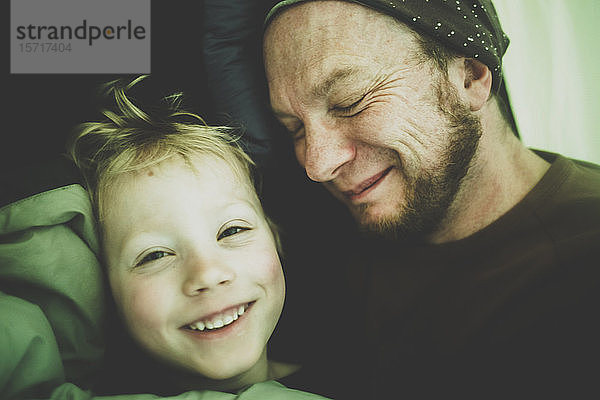 Porträt eines glücklichen kleinen Jungen und seines Vaters in einem Zelt