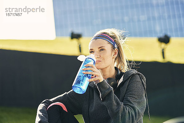Frau trinkt Wasser nach hartem Training