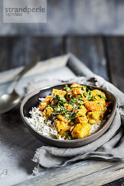 Schale mit veganem Curry mit Kartoffeln  Karotten  Erbsen  Petersilie und Kürbis
