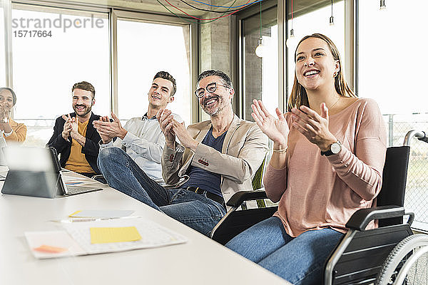 Glückliche Geschäftsleute applaudieren während einer Sitzung im Sitzungssaal