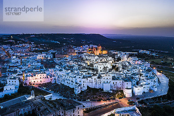 Italien  Provinz Brindisi  Ostuni  Luftaufnahme der Altstadtzitadelle umgeben von weißen Häusern in der Abenddämmerung