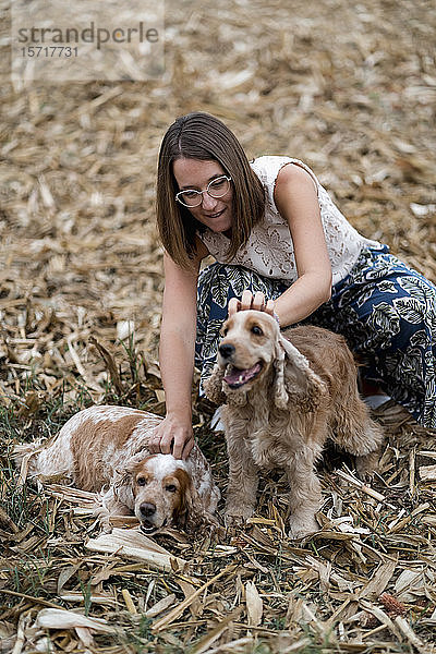 Frau auf einem Feld mit ihren Hunden
