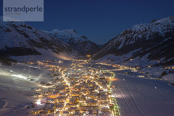 Italien  Provinz Sondrio  Livigno  Luftaufnahme einer beleuchteten Stadt in den italienischen Alpen in der Abenddämmerung
