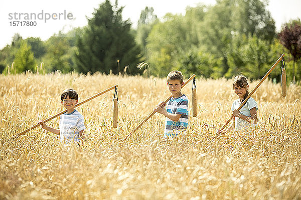 Kinder lernen  wie man Weizen auf dem Feld schleudert