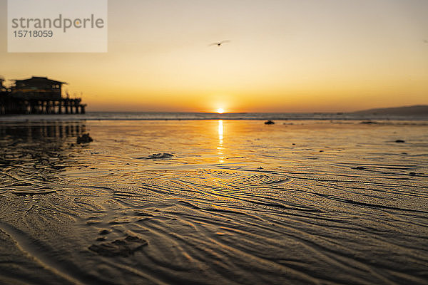 USA  Kalifornien  Santa Monica  Nasser Sand des Küstenstrandes bei Sonnenuntergang mit dem Santa Monica Pier im Hintergrund