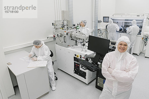 Porträt eines lächelnden Wissenschaftlers mit Kollegen im Labor