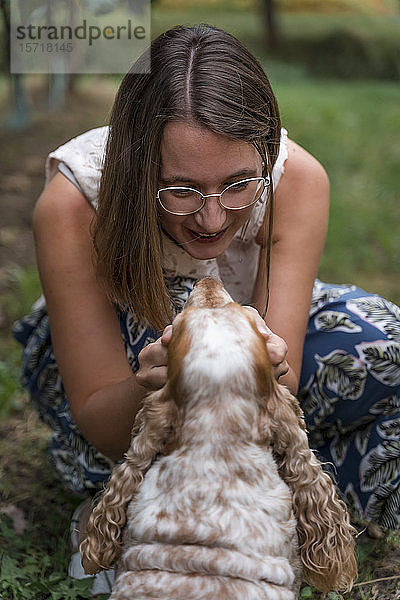 Frau auf einer Wiese mit ihrem Hund