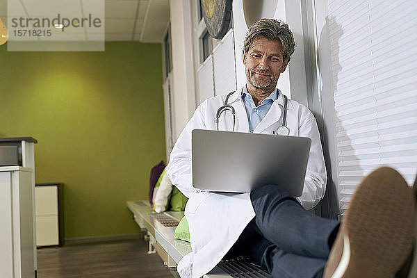Arzt benutzt Laptop in seiner Praxis