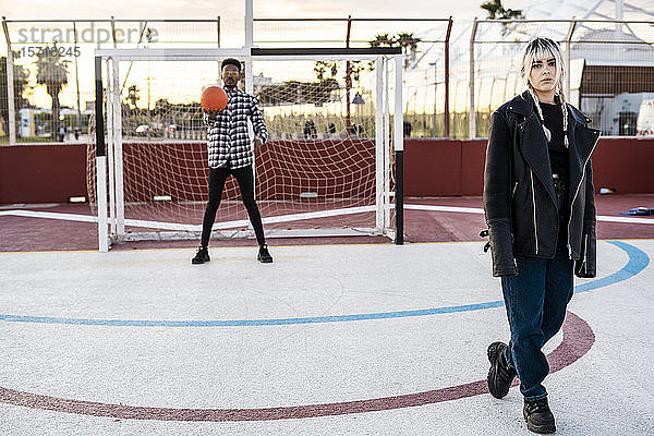 Junges Paar mit Basketball auf Sportplatz