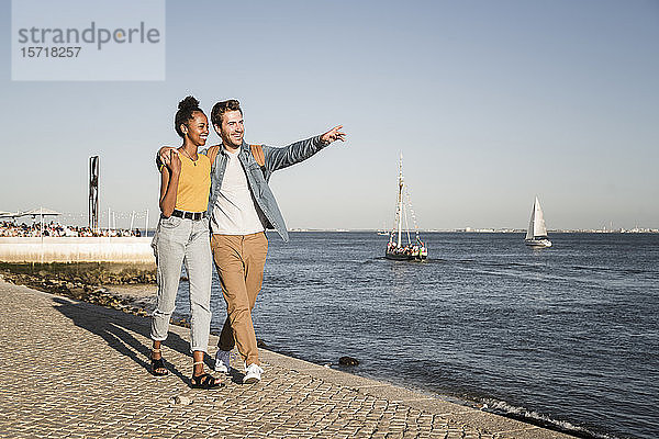 Glückliches junges Paar beim Spaziergang am Pier am Wasser  Lissabon  Portugal
