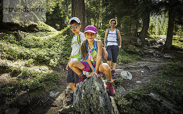 Porträt einer Mutter mit zwei Kindern beim Wandern in alpiner Landschaft  Passeiertal  Südtirol  Italien