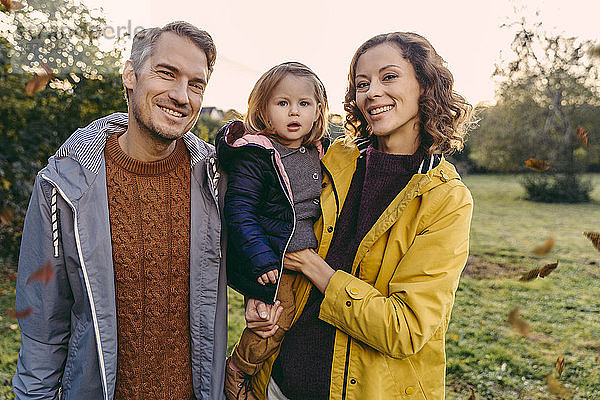 Porträt einer glücklichen Familie mit Tochter im Herbst im Freien
