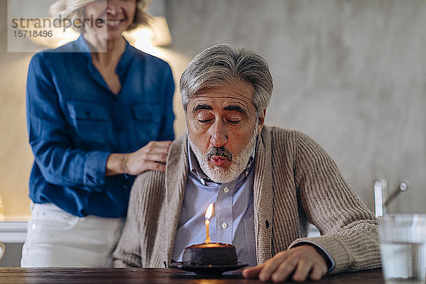 Älteres Paar feiert Geburtstag mit Kuchen in der heimischen Küche